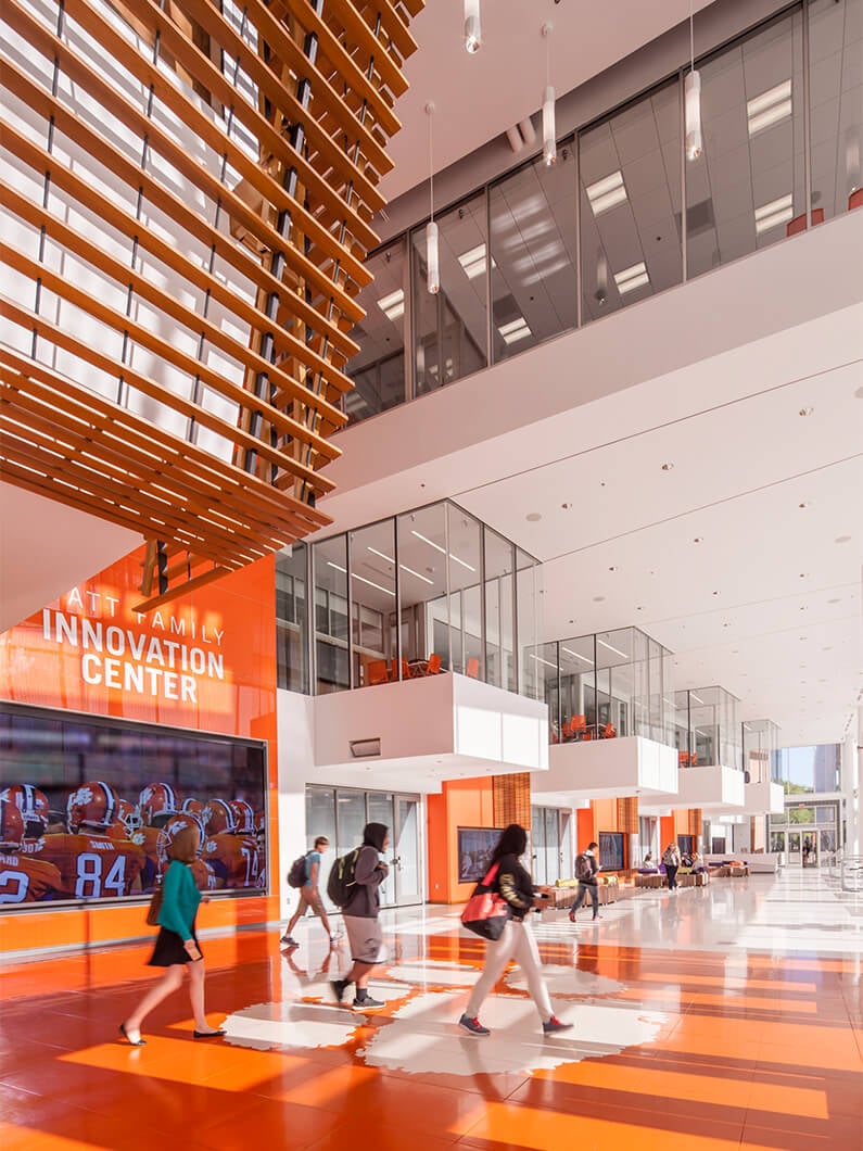 Modern innovation center lobby with people walking through bright, open space.