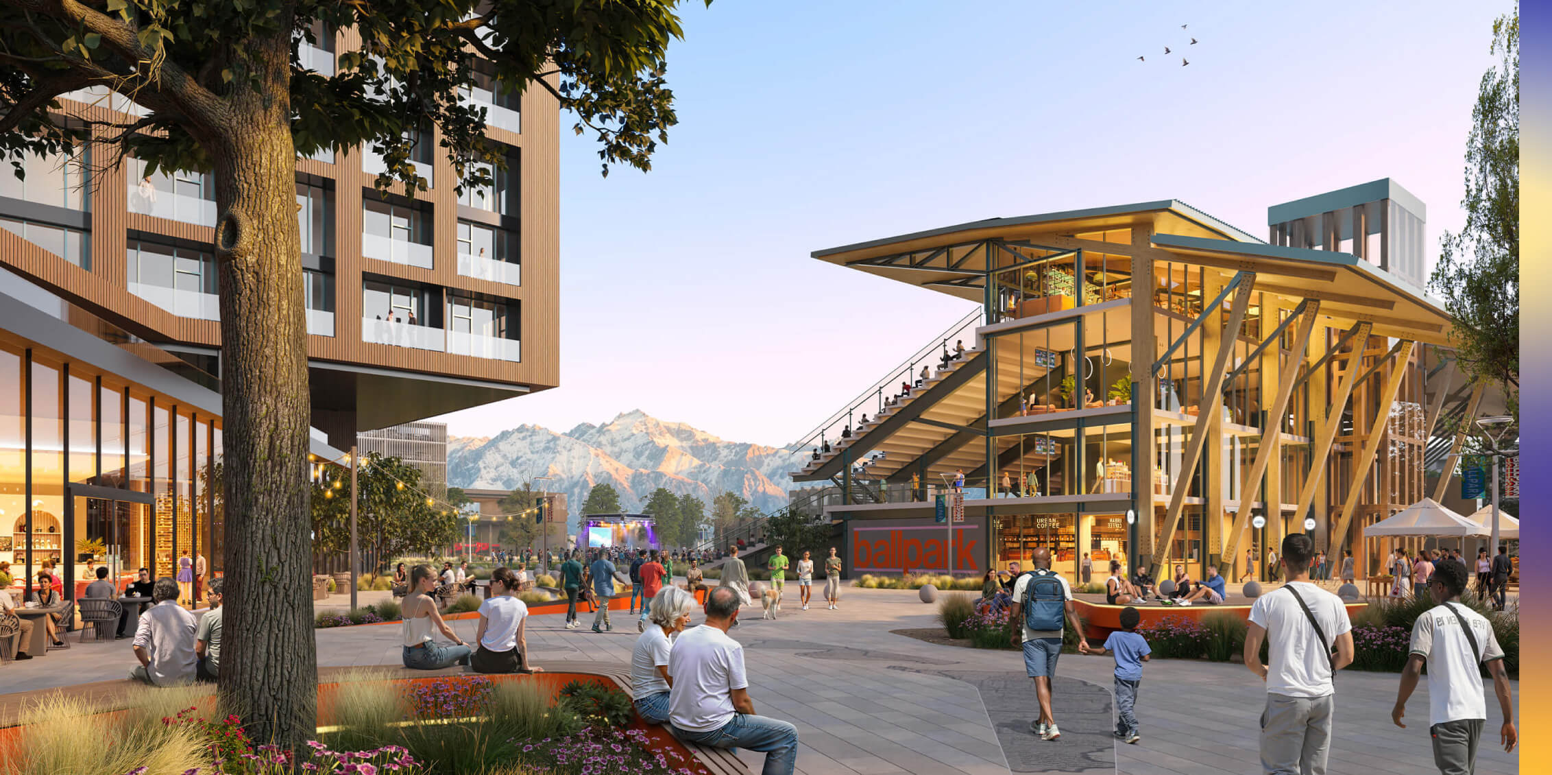 Modern plaza with people, shops, and mountain views at sunset.