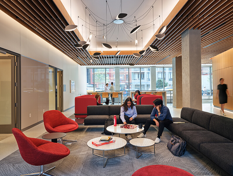 Student lounge with red seating and natural light.