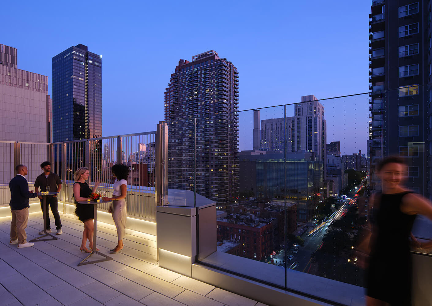 Rooftop evening gathering with cityscape view.