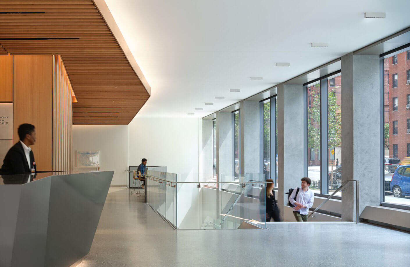 Student residential building lobby with wooden accents and large windows.