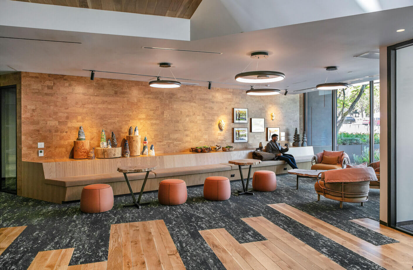 Modern lobby with wood accents, seating, and art display. Cozy and inviting atmosphere.