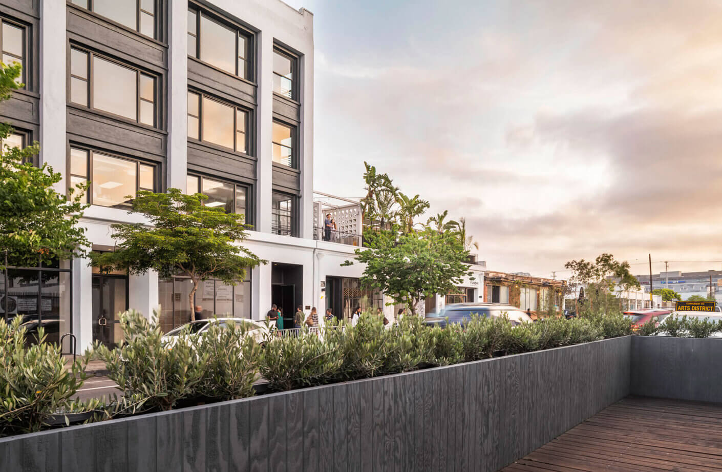 Modern urban street view with trees and stylish building at sunset.