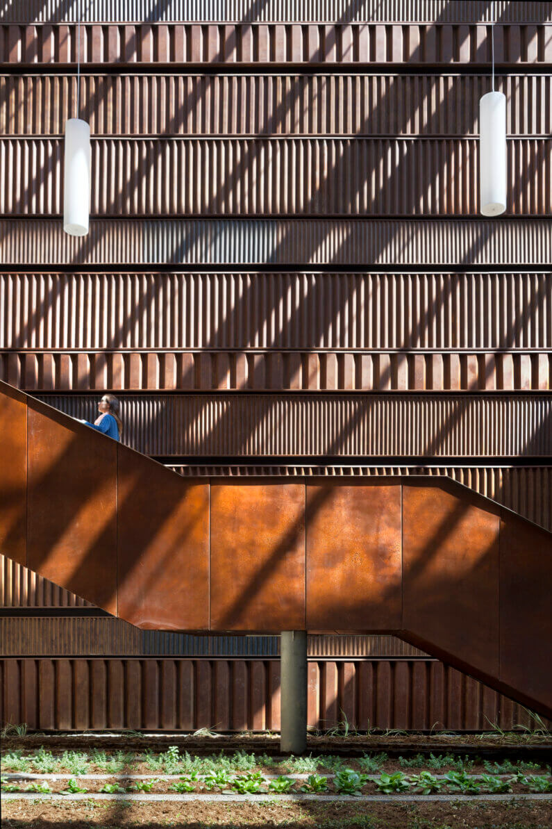 Modern staircase against textured wall, featuring light and shadow play.