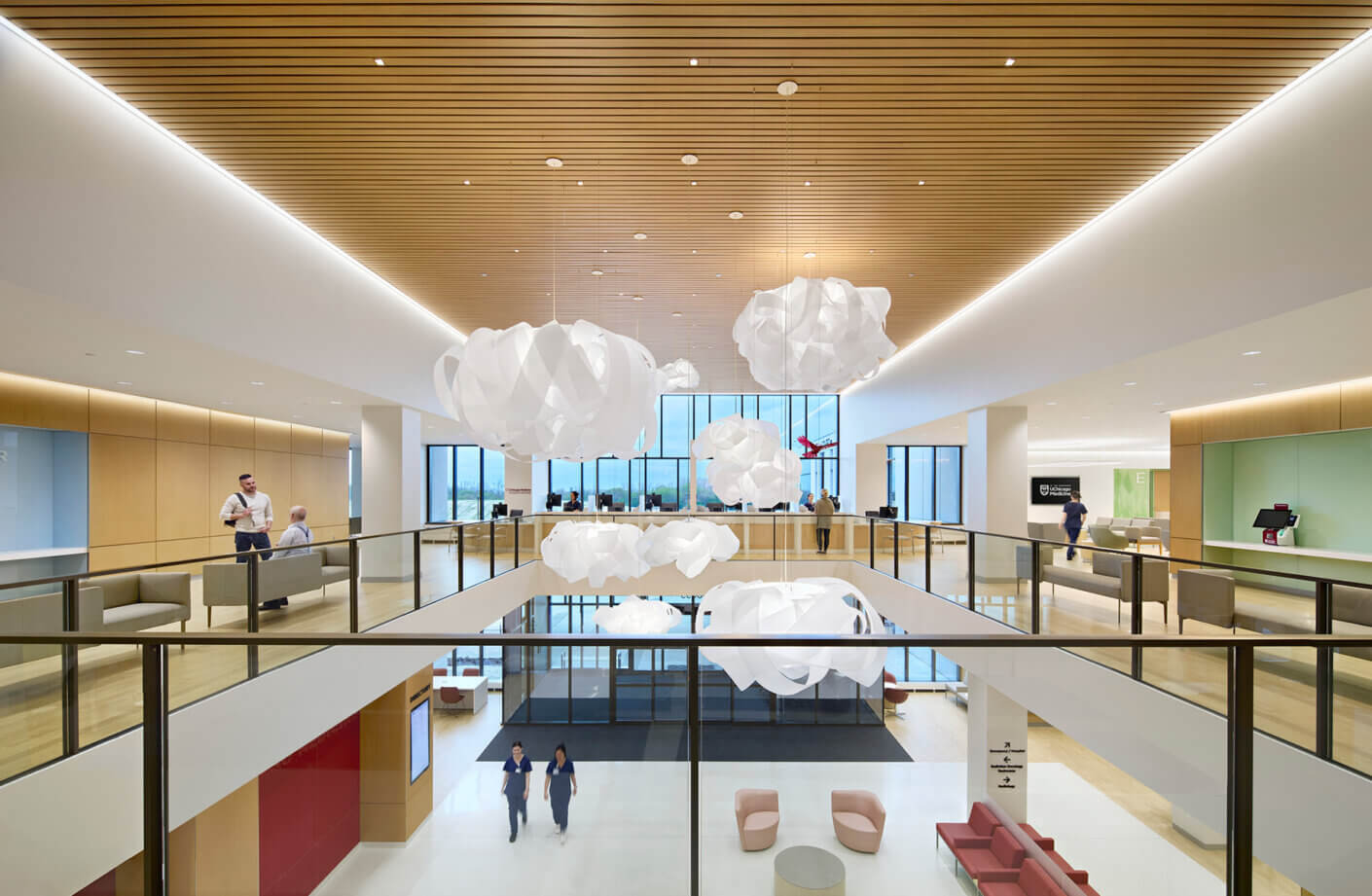 Modern office lobby with unique chandeliers and wood ceiling design.