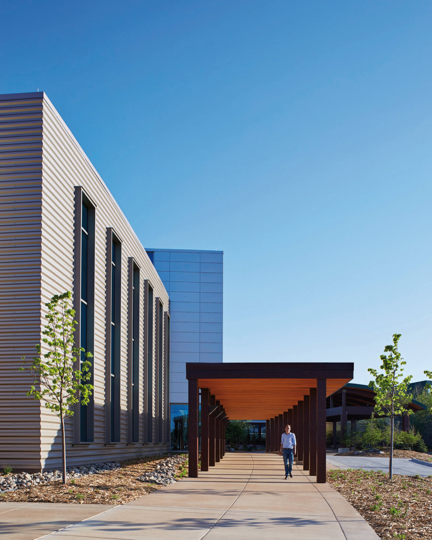 Modern medical office building with a walkway and clear blue sky in the background.