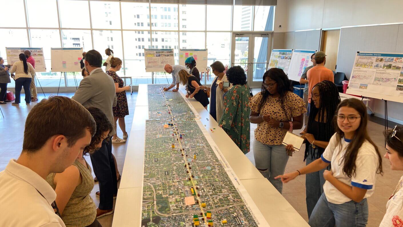 Community engagement event with people collaborating at a planning workshop table.