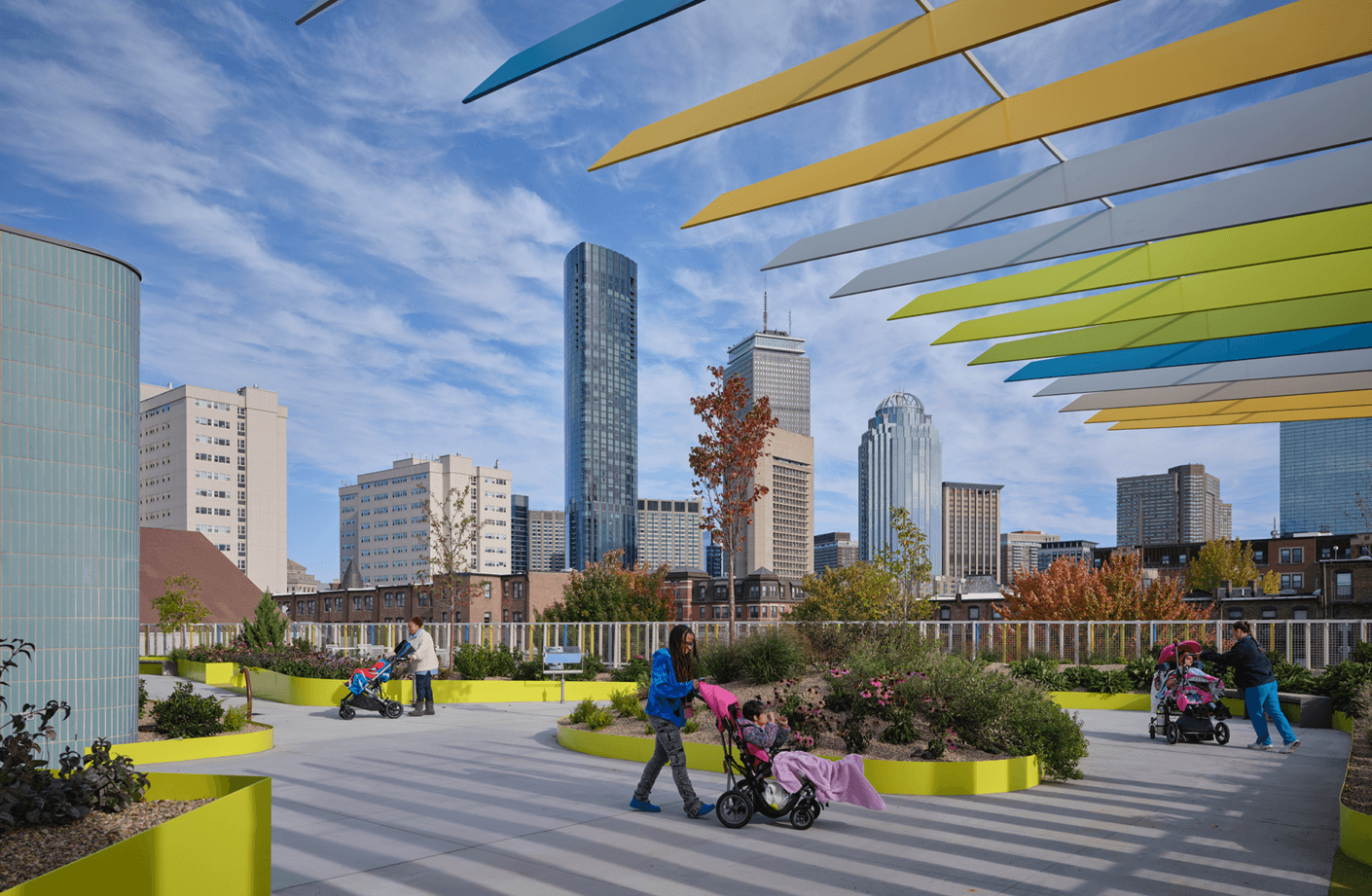 Colorful urban garden with teachers and students using wheelchairs against a city skyline backdrop.