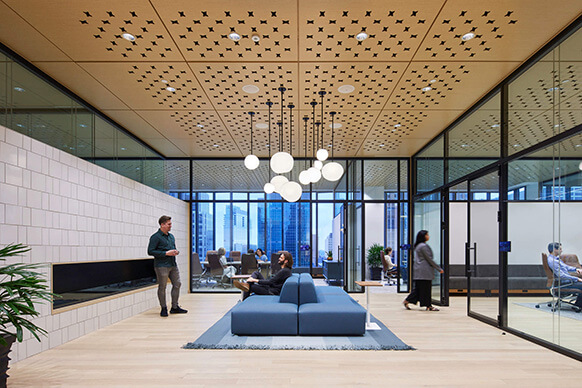 Modern office interior with glass walls, stylish furniture, and vibrant workspaces.