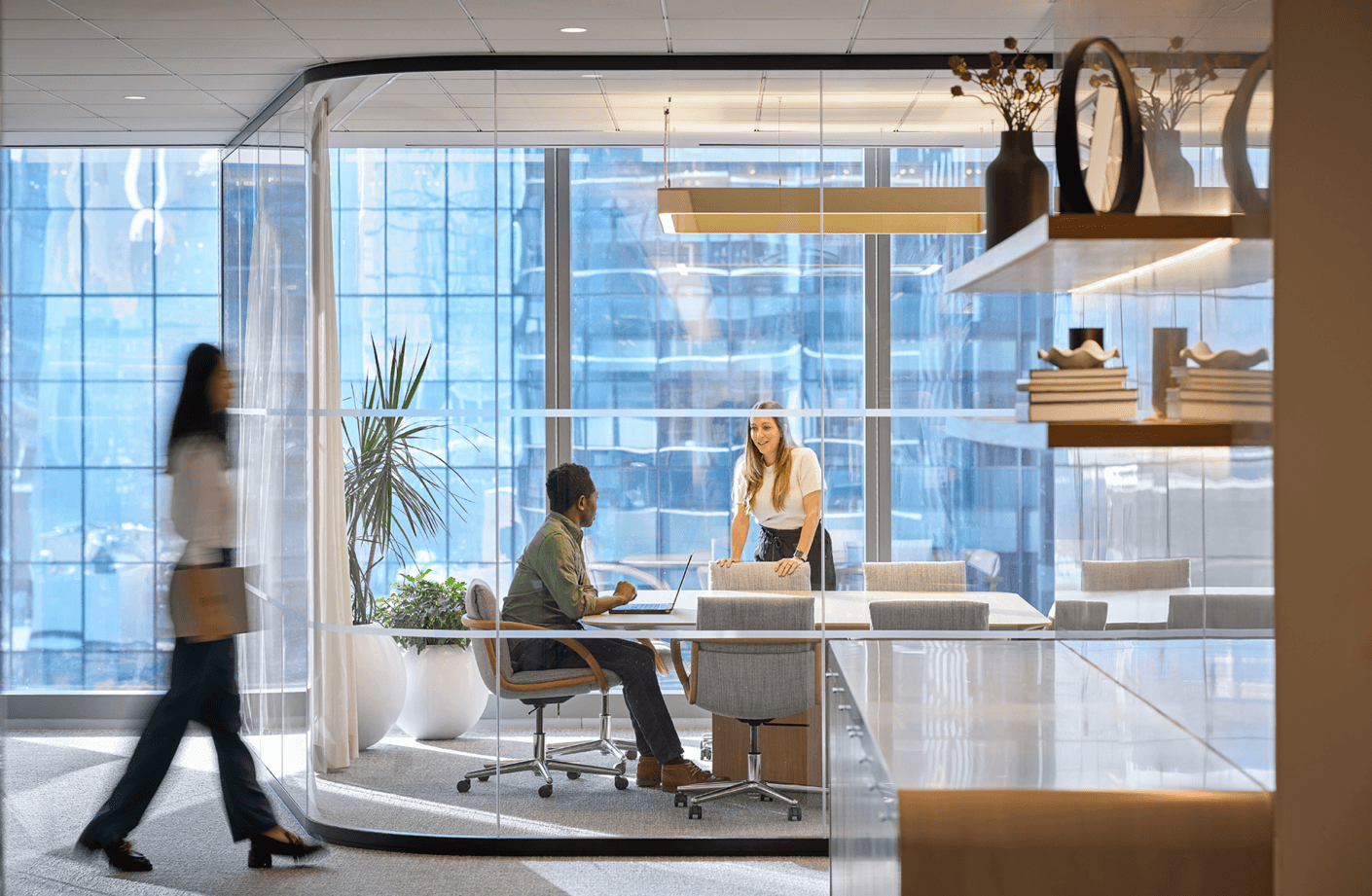 Rounded glass conference room with two people talking