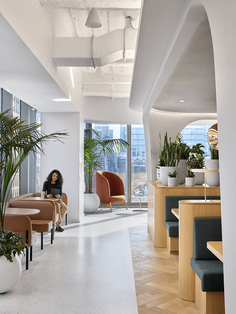 Office cafe space with booth seating to the right and tables to the left