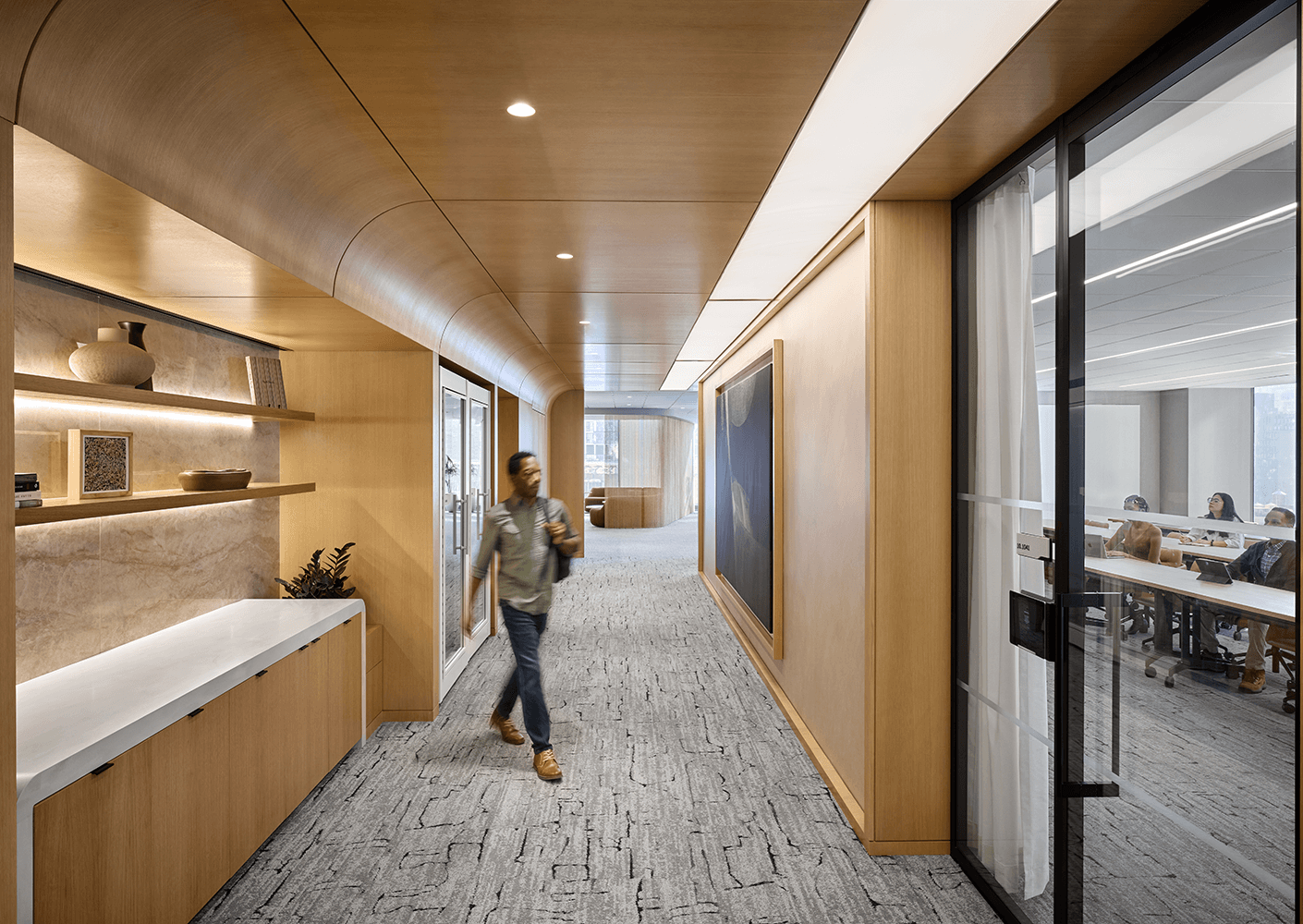 Curved warm wood hallway with conference room to the right
