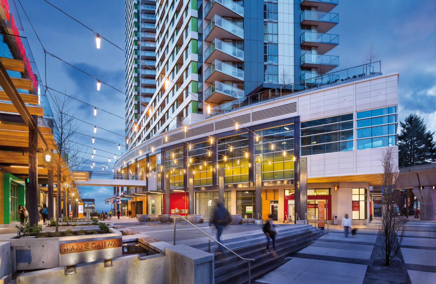 Modern mixed-use center with vibrant colors, glass façades, and landscaped entryway.