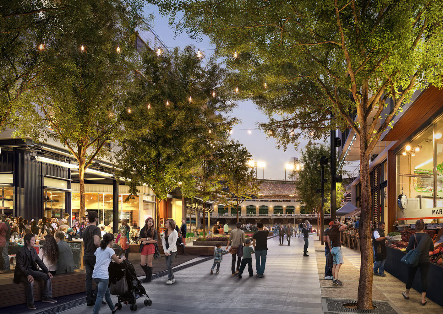 Open-air plaza lined with trees at night, featuring a mix of retail spaces, outdoor seating, and pedestrian pathways.