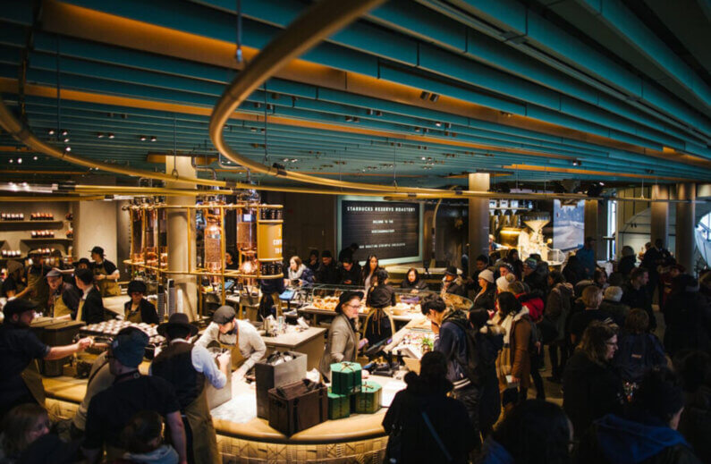 Modern coffee shop interior featuring curved ceilings and sleek copper brewing equipment.