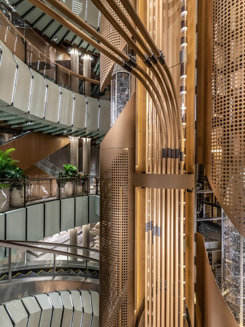 Interior architecture showcasing modern design elements, intricate textures, and lighting. Pipes carry coffee beans into a central funnel.