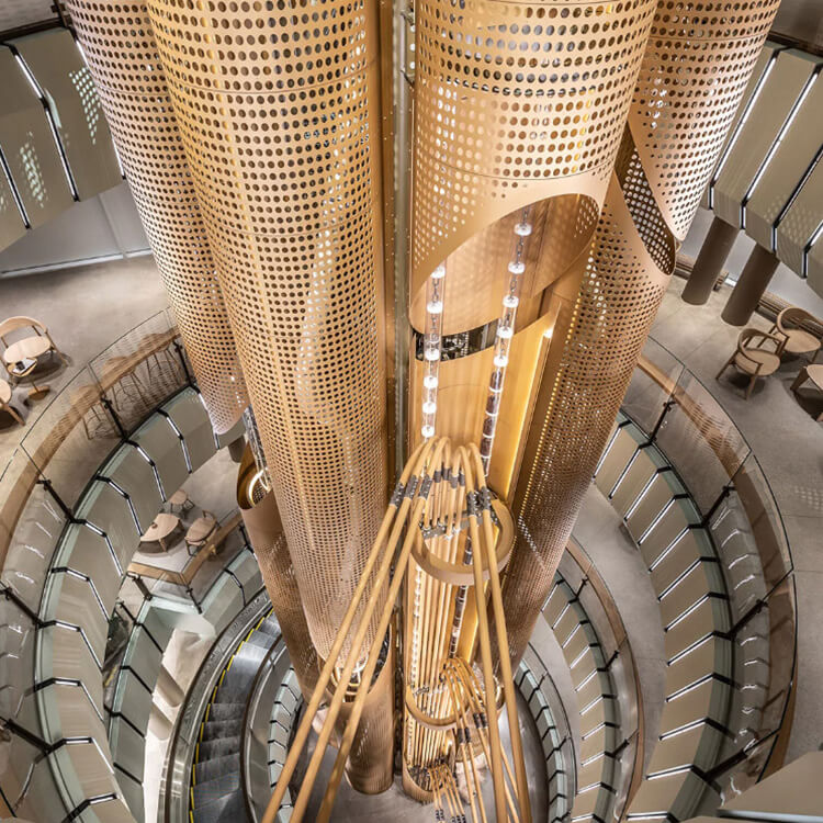 Modern architectural atrium with circular design and wooden accents. Elegant lighting. A 56-foot-tall cask in the center contains coffee beans.