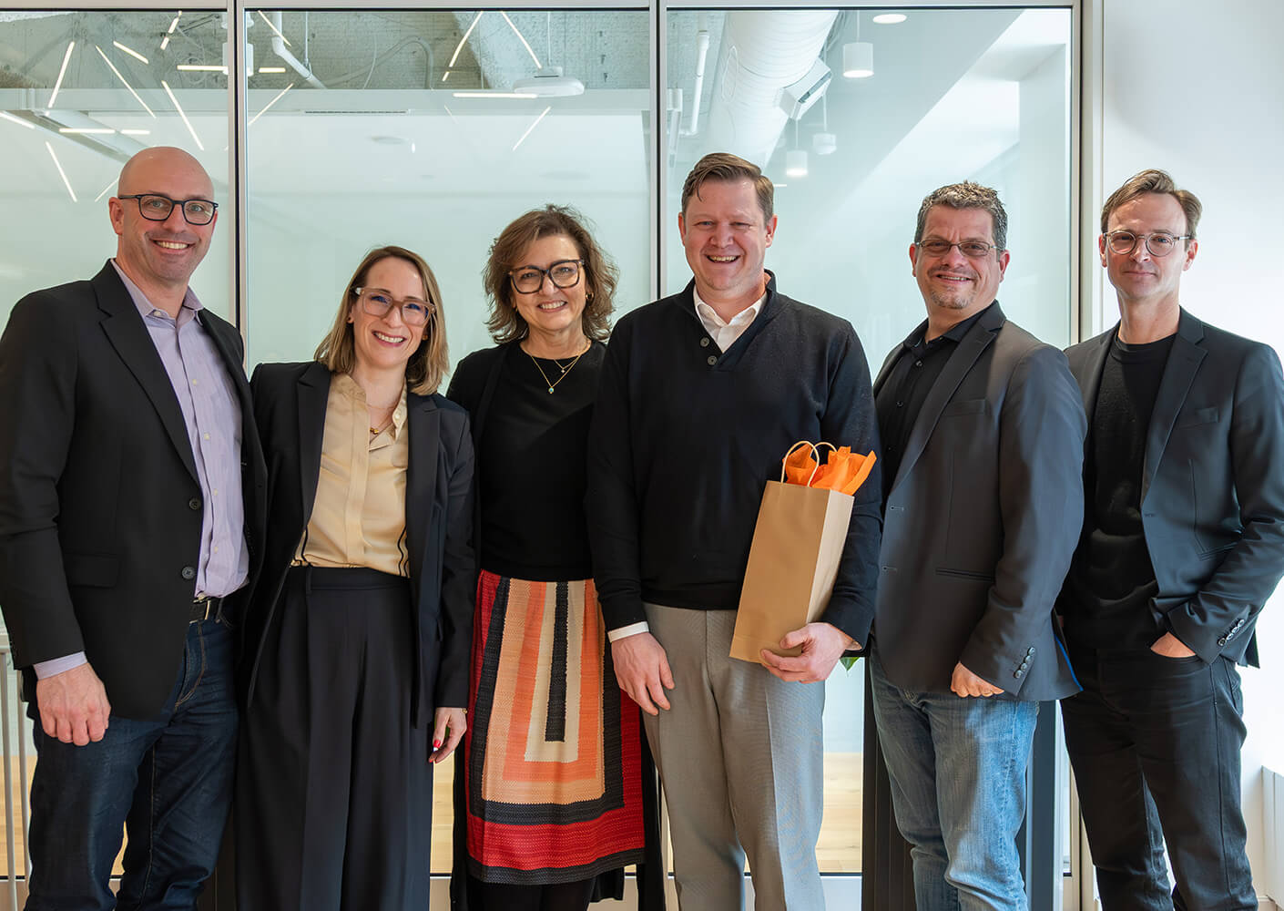 Jeffrey Keilman and Boston studio leadership posing together in an office setting.