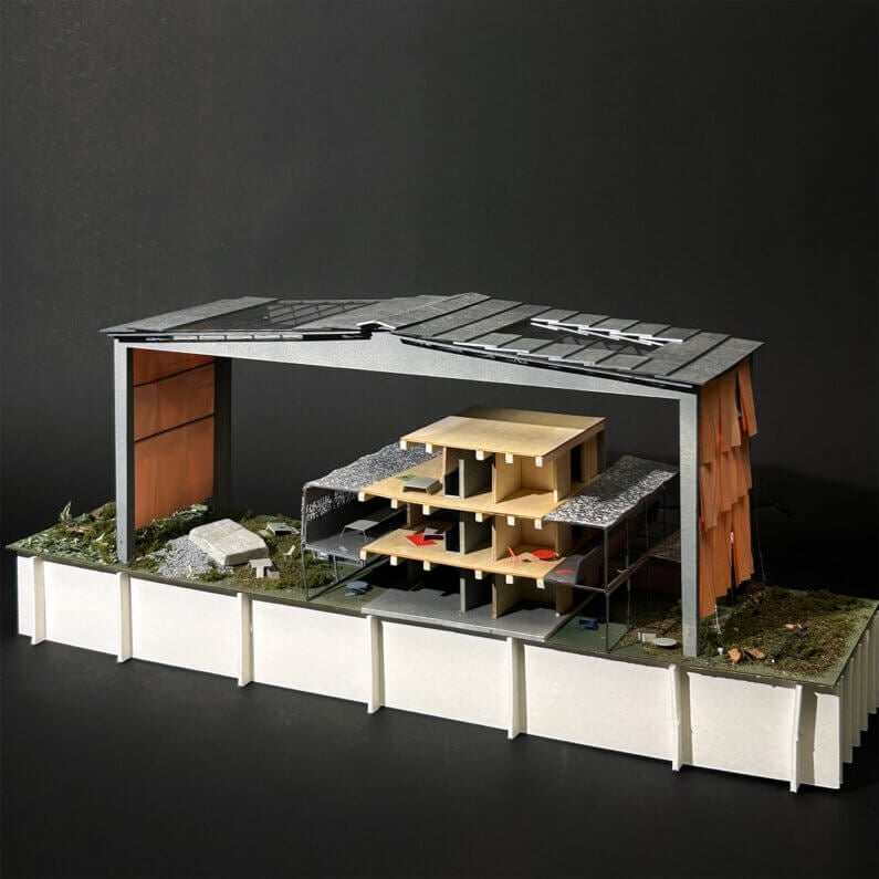 Scale model of a building featuring open spaces, layered structure, and mixed materials, set against a dark background.