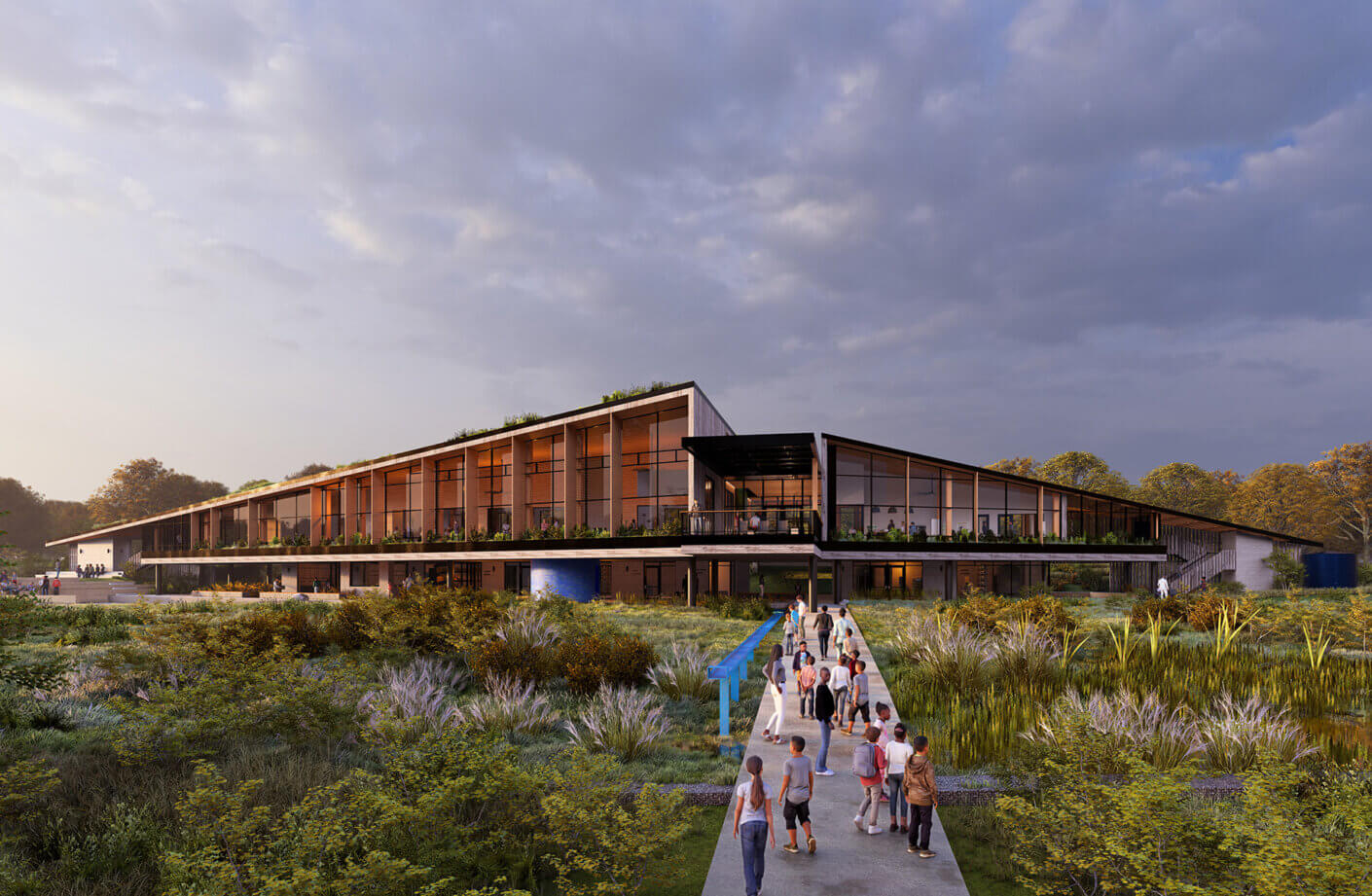 A new building with expansive windows and outdoor space, surrounded by lush vegetation and visitors on a pathway approaching the entrance.