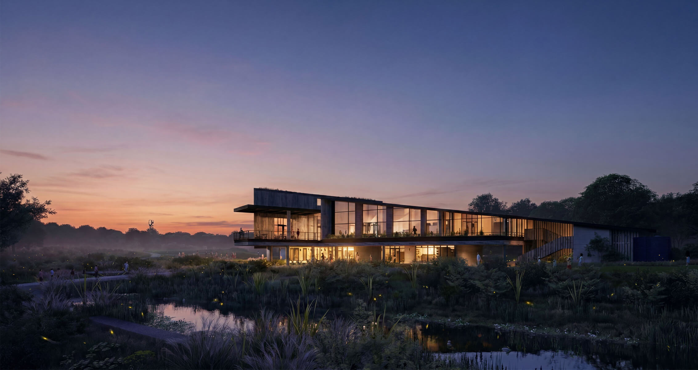 Architectural structure at dusk, featuring large windows, surrounded by landscaping and water, with people walking nearby.