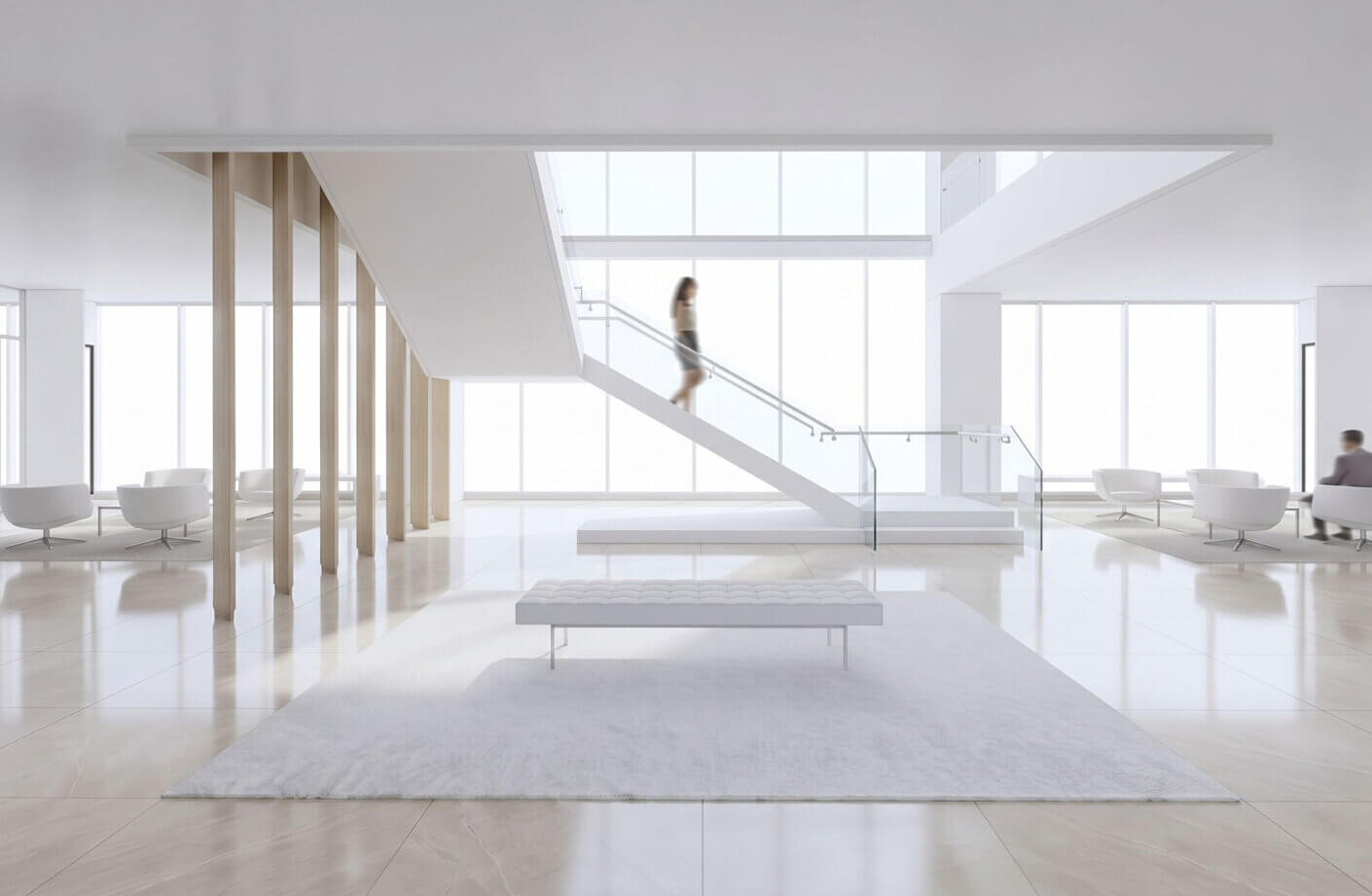 Bright indoor space featuring a staircase, white seating, and light wood accents. A person walks up the stairs, showcasing the open design.