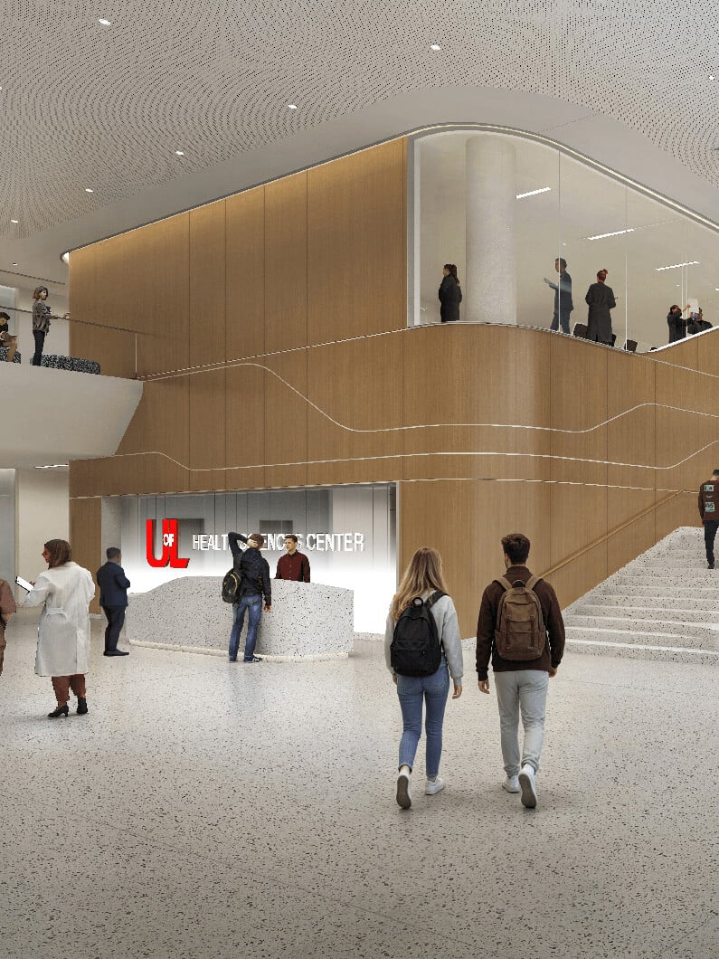 Interior of U of L Health Sciences Center featuring a reception area, staircase, and visitors. People engaged in various activities in the lobby.