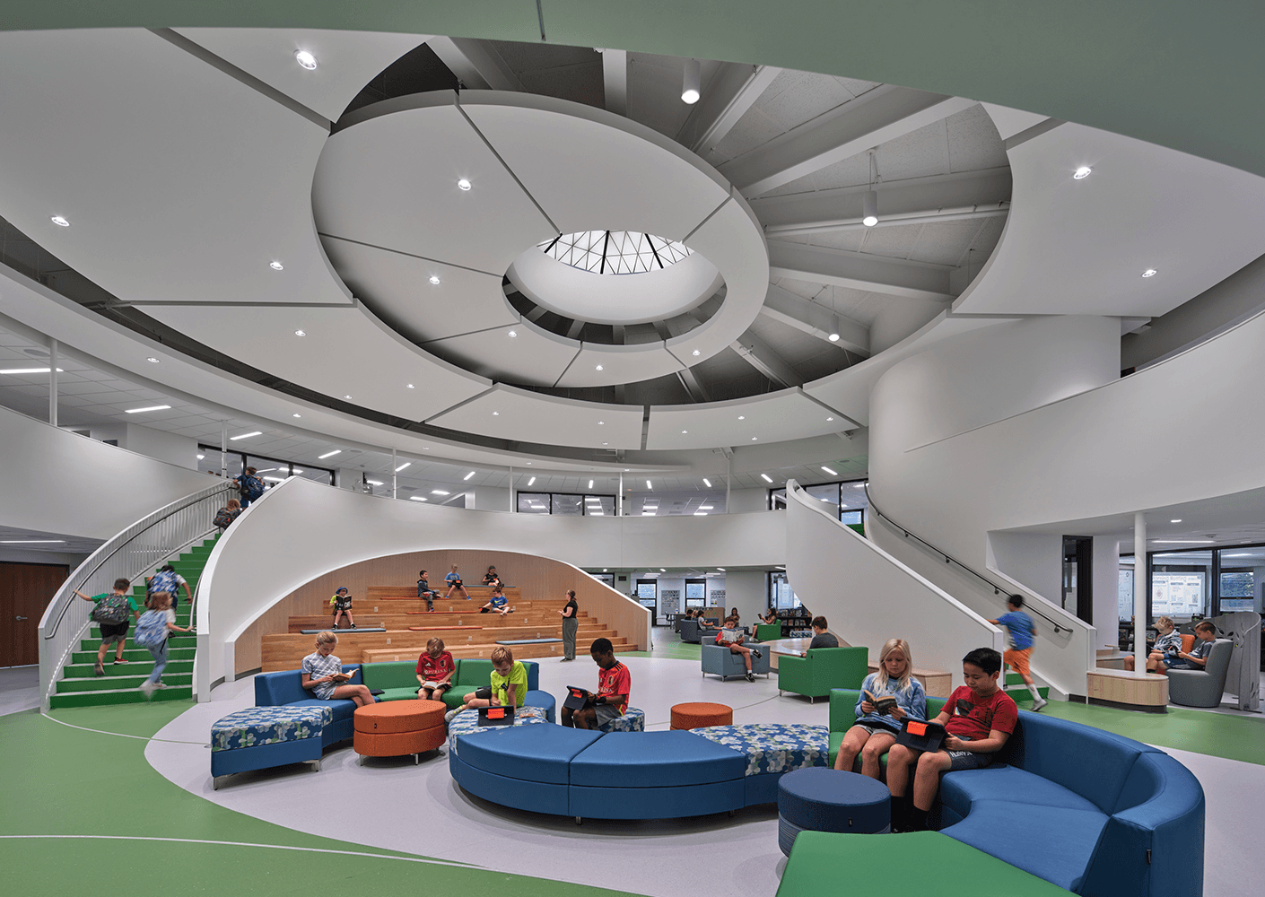 Children read and engage in activities in a brightly lit, spacious library with unique seating and architectural features.