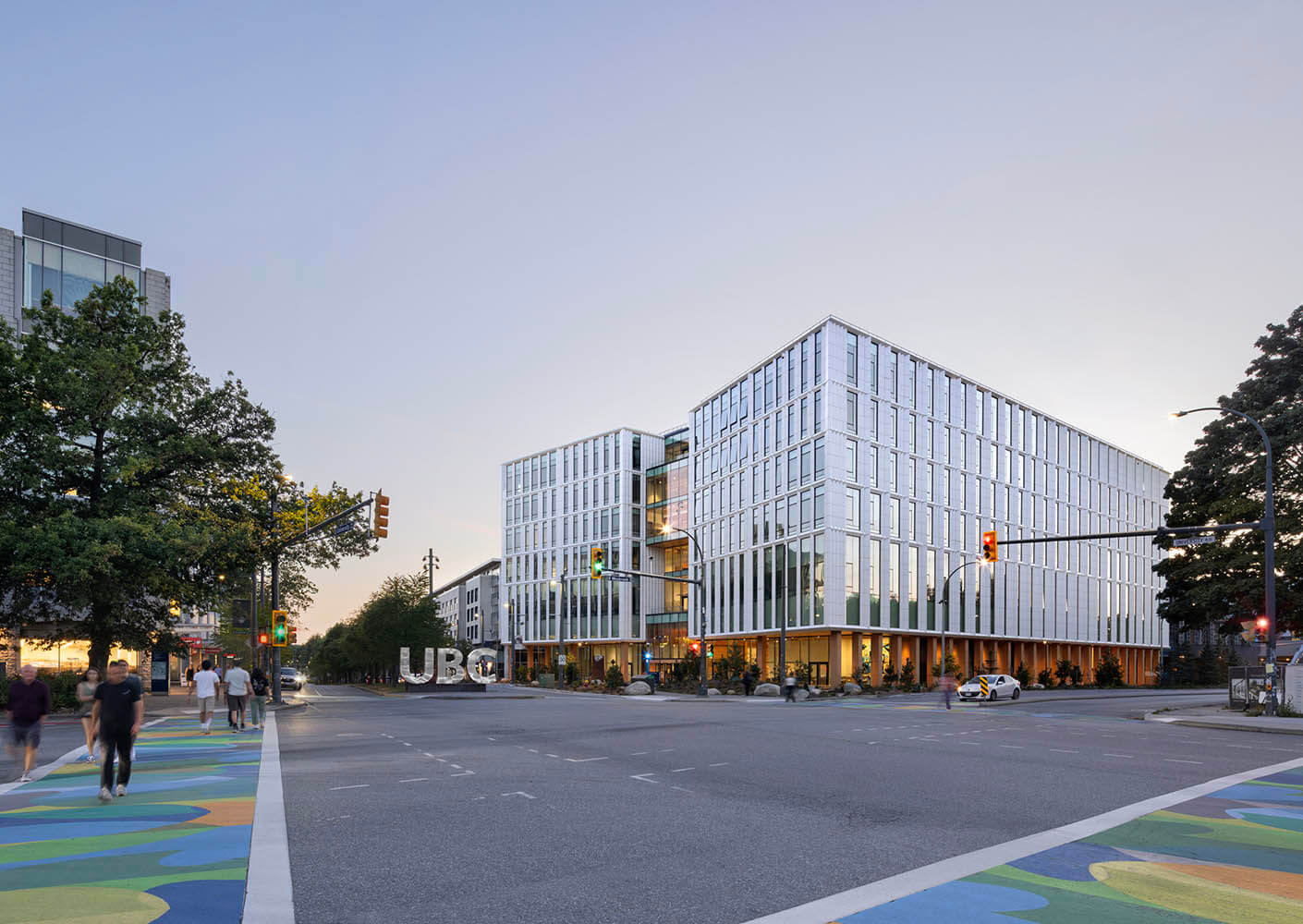 Exterior dusk view showing campus arrival with UBC MacIsaac Health Building on the right side