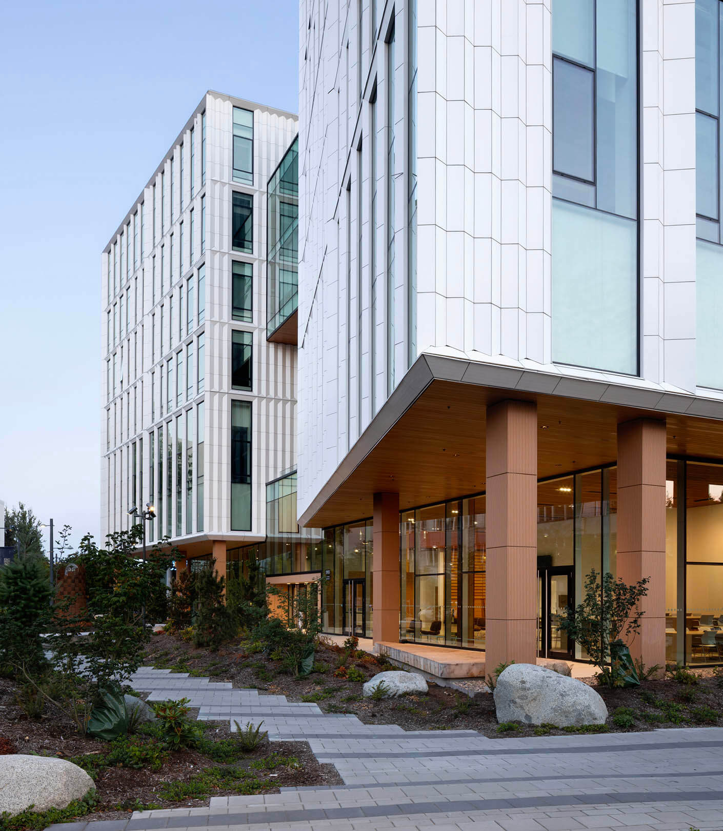 Exterior daytime view of UBC MacIsaac Health Building showing Indigenous landscape and porous ground plane