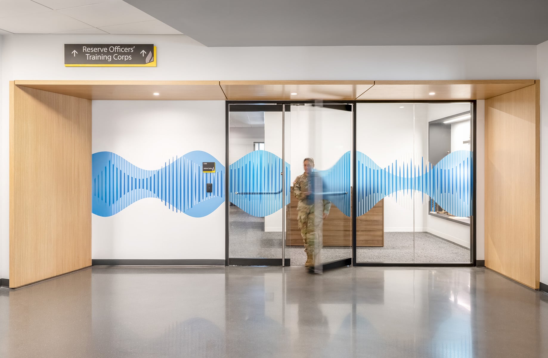 Entrance to the Reserve Officers' Training Corps featuring a decorative blue soundwave design on glass doors and wooden accents in the interior.