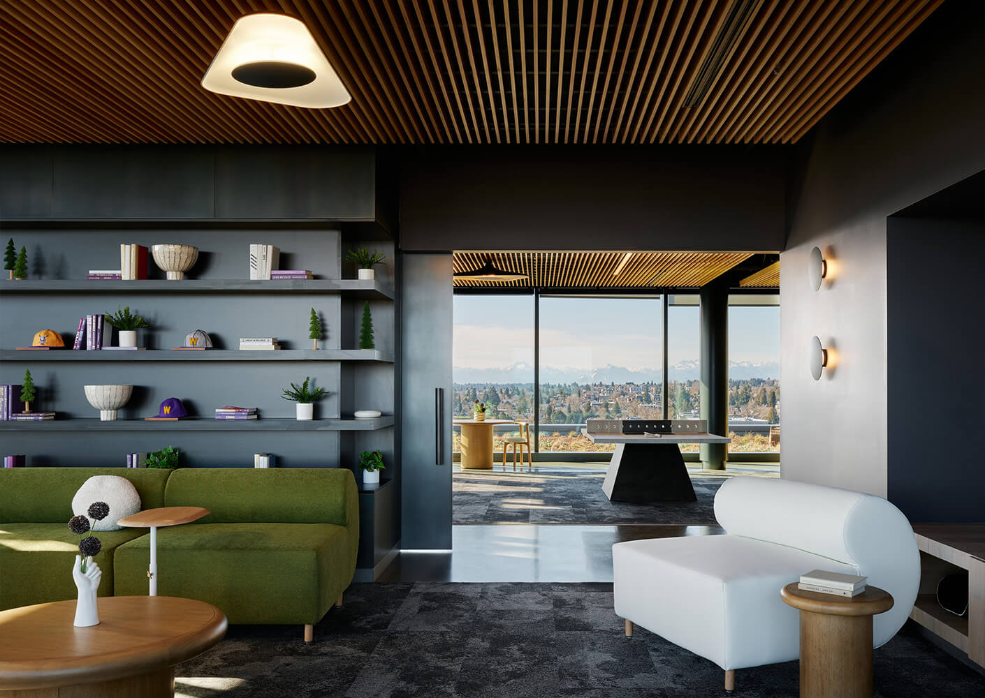 Spacious lounge area featuring a green sofa, white chair, and decorative shelving, with large windows showcasing a mountain view.