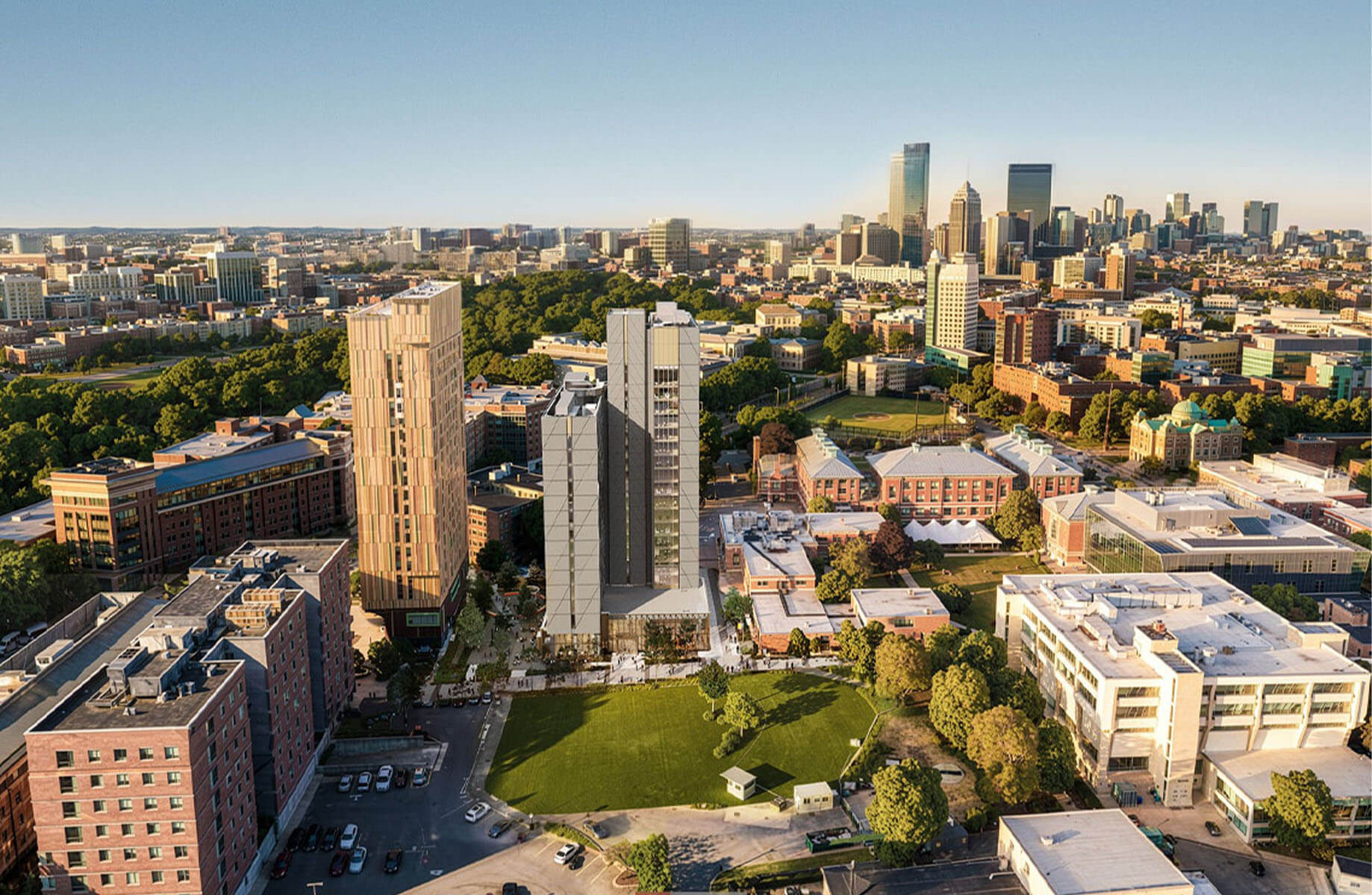 Aerial view of an urban area featuring several tall buildings, green spaces, and surrounding cityscape with skyline in the background.
