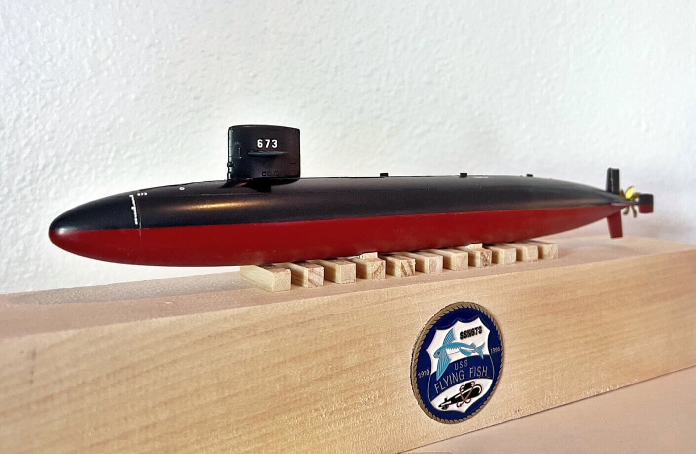 Model submarine USS Flying Fish (SSN 673) displayed on a wooden base with a plaque, showcasing detailed craftsmanship and design.